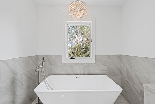 12 Foxhurst Ct, Manhasset Hills, NY 11040 - bathroom with tile walls, a soaking tub, a chandelier, and wainscoting