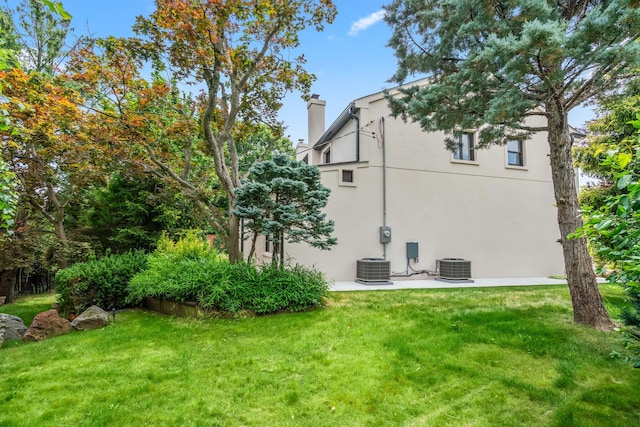 12 Foxhurst Ct, Manhasset Hills, NY 11040 - rear view of property with a chimney, a yard, and stucco siding