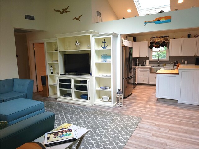 67 Wakeman Rd, Hampton Bays, NY 11946 - living room with a skylight, high vaulted ceiling, light wood-style floors, and recessed lighting