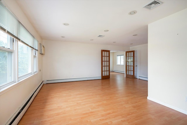 21 Silver St, West Babylon, NY 11704 - spare room with a baseboard heating unit, light wood-style floors, recessed lighting, baseboard heating, and a wall mounted AC