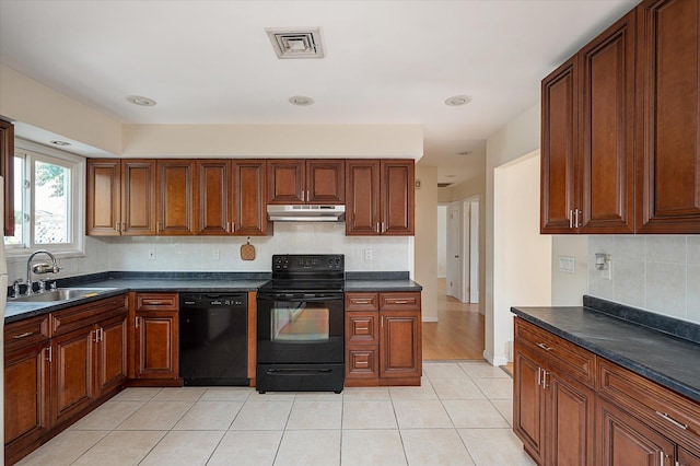 21 Silver St, West Babylon, NY 11704 - kitchen with black appliances, under cabinet range hood, dark countertops, and decorative backsplash