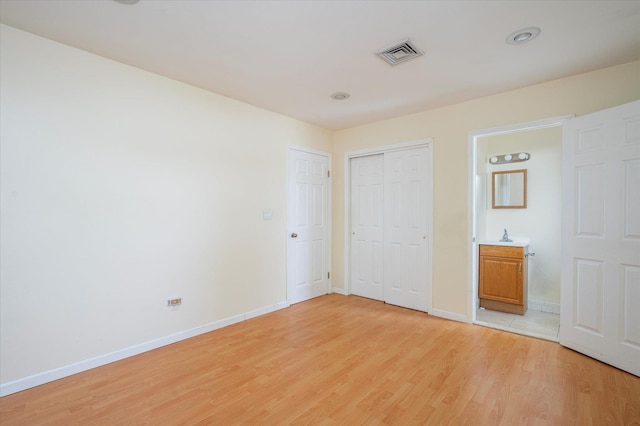 21 Silver St, West Babylon, NY 11704 - unfurnished bedroom with light wood-style floors, connected bathroom, and a closet