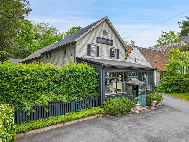259 Westchester Ave, Pound Ridge, NY 10576 - view of front of house with a sunroom and a shingled roof