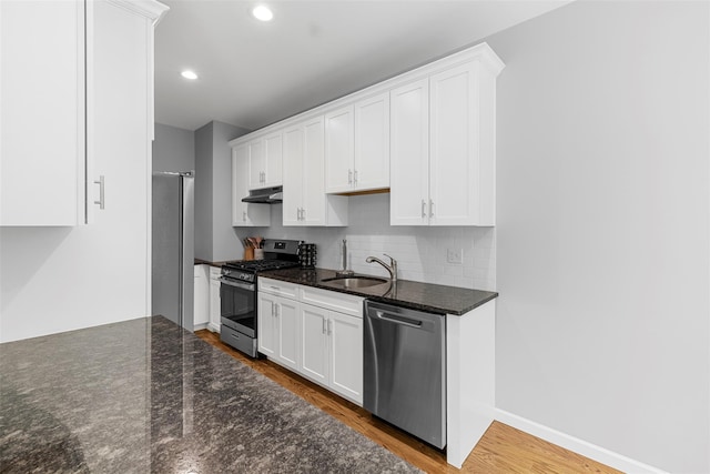 28 Pinto Rd W, Middletown, NY 10941 - kitchen featuring appliances with stainless steel finishes, white cabinets, under cabinet range hood, wood finished floors, and decorative backsplash