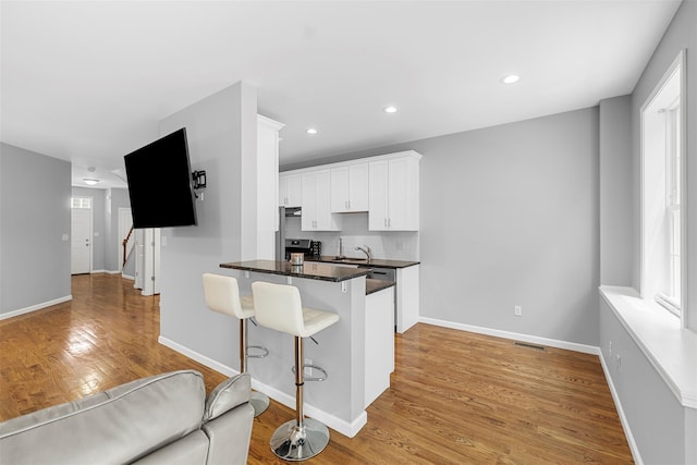 28 Pinto Rd W, Middletown, NY 10941 - kitchen with a kitchen breakfast bar, white cabinets, light wood-style floors, recessed lighting, and a peninsula