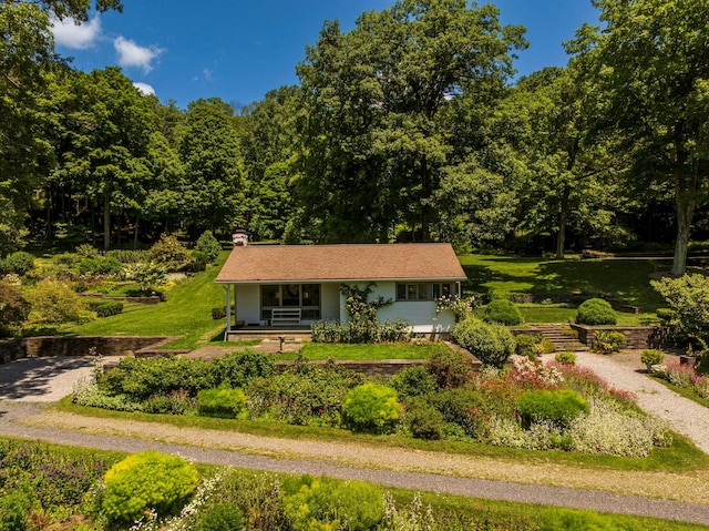 447 Butts Hollow Rd, Dover Plains, NY 12522 - view of front of house with a porch, a chimney, gravel driveway, and a wooded view