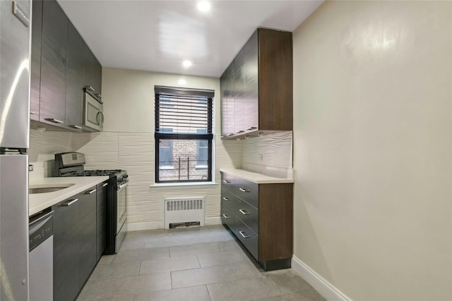 445 W 240th St Unit 4C, Bronx, NY 10463 - kitchen featuring stainless steel appliances, light countertops, radiator heating unit, light tile patterned floors, and recessed lighting