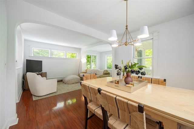22 Tompkins Ave, Beacon, NY 12508 - dining space featuring arched walkways, a chandelier, dark wood-style floors, and plenty of natural light