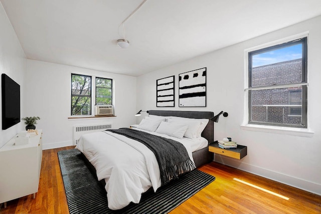 2420 Morris Ave Unit 6K, Bronx, NY 10468 - bedroom with radiator, wood finished floors, and cooling unit