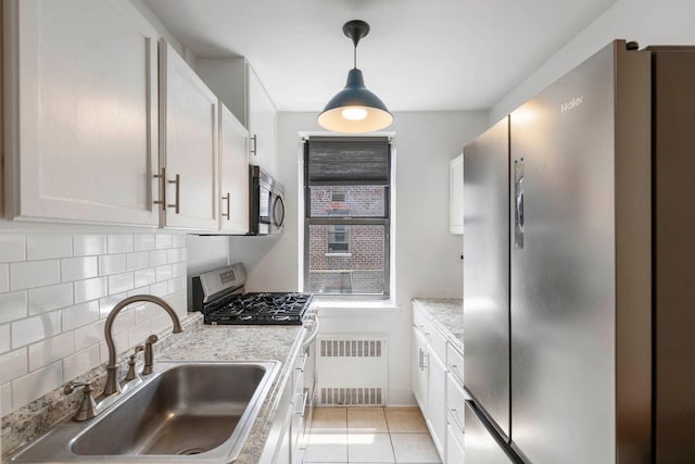 2420 Morris Ave Unit 6K, Bronx, NY 10468 - kitchen with stainless steel appliances, decorative backsplash, radiator heating unit, light tile patterned floors, and pendant lighting
