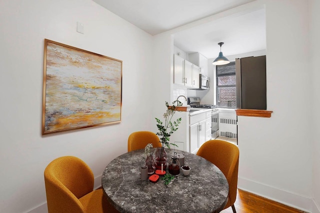 2420 Morris Ave Unit 6K, Bronx, NY 10468 - dining room featuring radiator and light wood finished floors