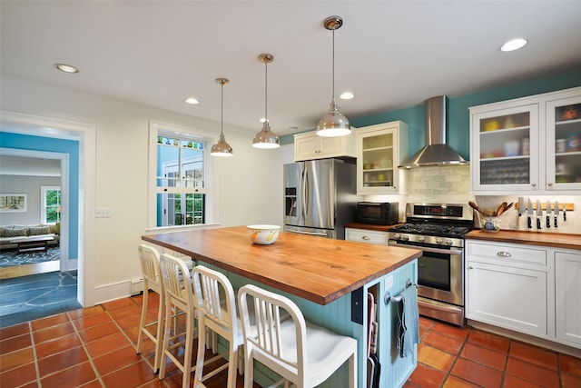 10 King St, Croton-On-Hudson, NY 10520 - kitchen with butcher block counters, wall chimney range hood, stainless steel appliances, decorative backsplash, and white cabinetry