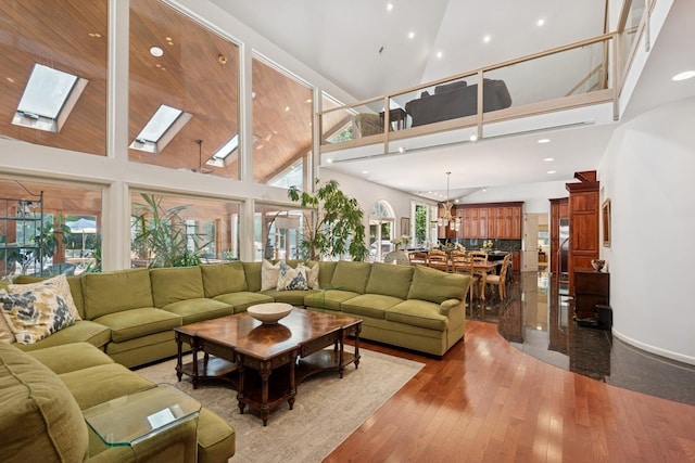 9 Swan Pl, Nissequogue, NY 11780 - living room with a high ceiling, dark wood-style flooring, a skylight, and recessed lighting