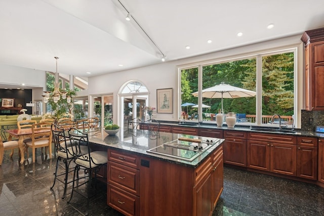 9 Swan Pl, Nissequogue, NY 11780 - kitchen with granite tiled floors, stovetop with downdraft, a breakfast bar, recessed lighting, and rail lighting