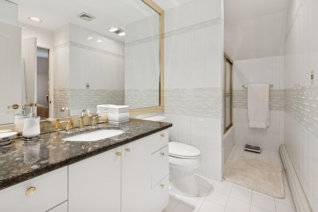 9 Swan Pl, Nissequogue, NY 11780 - full bathroom featuring tile walls, tile patterned floors, vanity, a baseboard radiator, and combined bath / shower with glass door