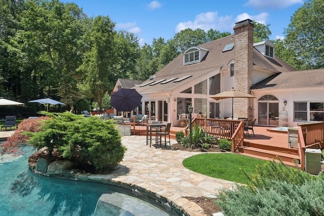 9 Swan Pl, Nissequogue, NY 11780 - back of property with a wooden deck, outdoor dining space, a chimney, roof with shingles, and an outdoor pool
