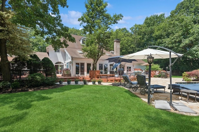 9 Swan Pl, Nissequogue, NY 11780 - back of property with a lawn, a patio, a chimney, and a shingled roof