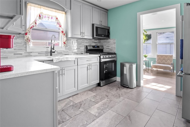 550 Armond St, Uniondale, NY 11553 - kitchen featuring stainless steel appliances, backsplash, and light stone counters