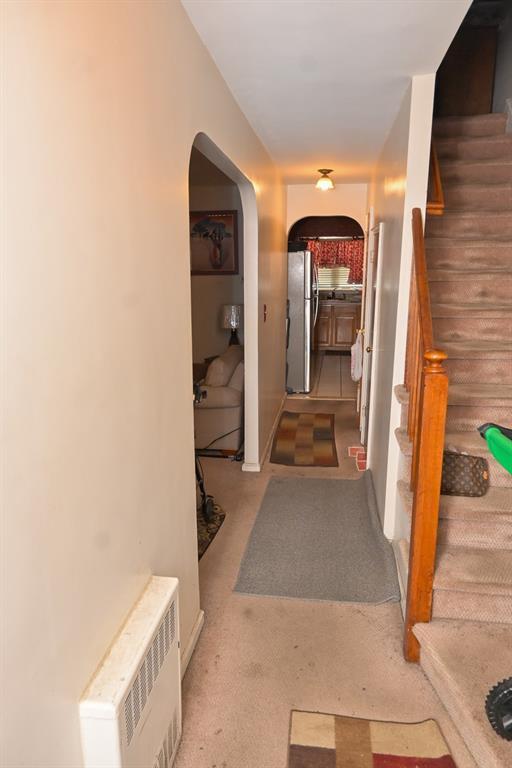 3331 Hone Ave, Bronx, NY 10469 - hallway featuring stairs, arched walkways, and light colored carpet