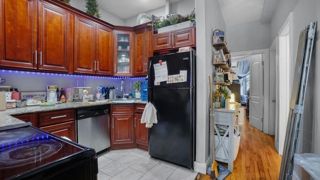 1050 Morris Ave, Bronx, NY 10456 - kitchen with black appliances, light stone countertops, glass insert cabinets, and reddish brown cabinets