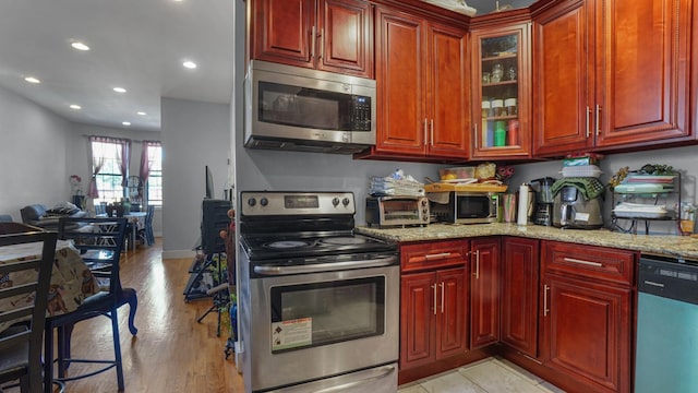 1050 Morris Ave, Bronx, NY 10456 - kitchen featuring appliances with stainless steel finishes, dark brown cabinets, light stone countertops, recessed lighting, and glass insert cabinets