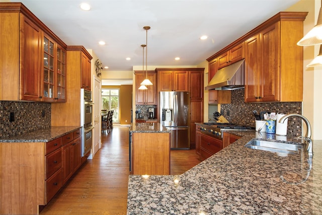 115 Highland Rd, Southampton, NY 11968 - kitchen featuring appliances with stainless steel finishes, under cabinet range hood, light wood-type flooring, a kitchen island, and dark stone counters