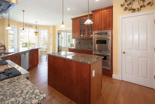 115 Highland Rd, Southampton, NY 11968 - kitchen featuring appliances with stainless steel finishes, a kitchen island, tasteful backsplash, recessed lighting, and glass insert cabinets
