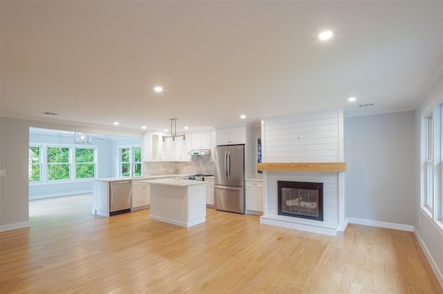 20 Oak Grove Rd, Southampton, NY 11968 - kitchen with a kitchen island, ornamental molding, appliances with stainless steel finishes, white cabinetry, and light countertops