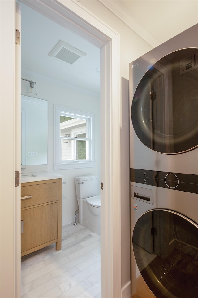 20 Oak Grove Rd, Southampton, NY 11968 - bathroom featuring estacked washer and dryer, vanity, and ornamental molding