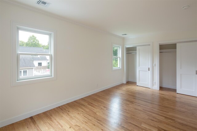 20 Oak Grove Rd, Southampton, NY 11968 - unfurnished bedroom featuring two closets, crown molding, and light wood-style floors
