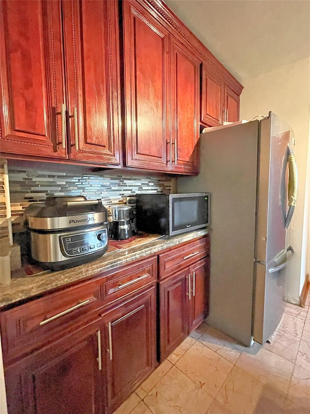 84-31 Van Wyck Expy Unit 5F, Briarwood, NY 11435 - kitchen with light marble finish flooring, dark brown cabinets, decorative backsplash, and appliances with stainless steel finishes