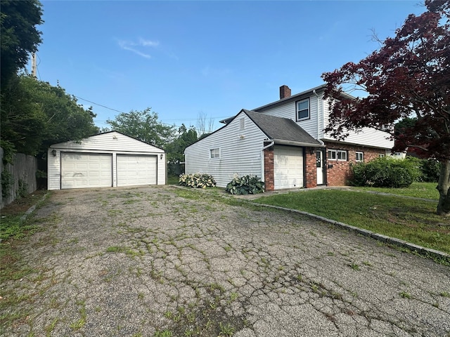 63 Grape Ln, Hicksville, NY 11801 - view of side of home with a garage, brick siding, a chimney, and an outbuilding
