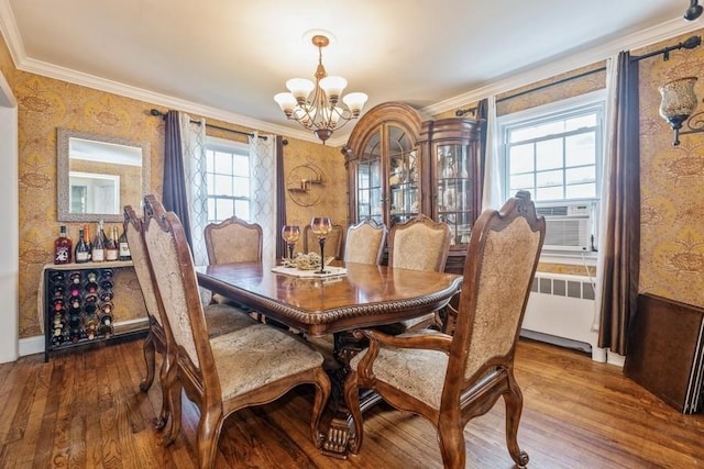 369 S 16th St, Lindenhurst, NY 11757 - dining space with a chandelier, ornamental molding, radiator heating unit, wood finished floors, and wallpapered walls