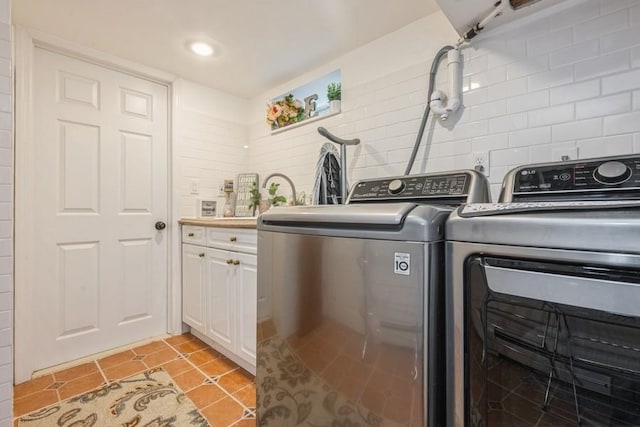 369 S 16th St, Lindenhurst, NY 11757 - washroom with separate washer and dryer, cabinet space, and light tile patterned floors