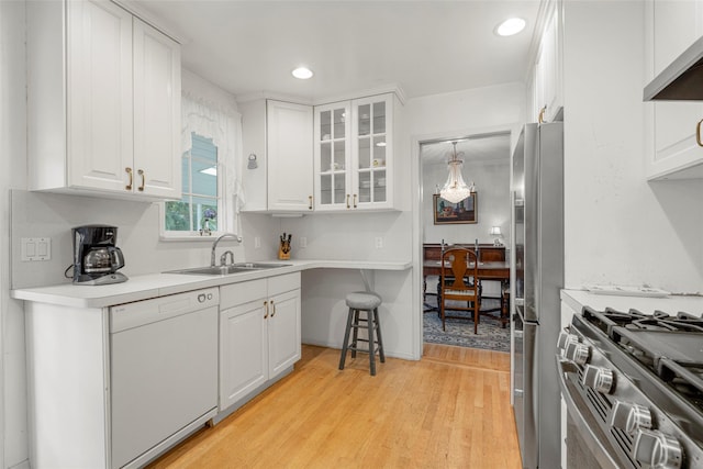 16 Ria Dr, White Plains, NY 10605 - kitchen featuring appliances with stainless steel finishes, white cabinets, light wood-style flooring, glass insert cabinets, and extractor fan