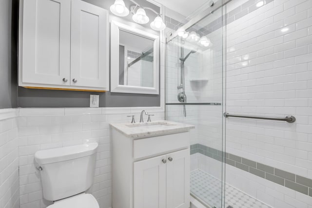 6 Birchwood Ct Unit 5N, Mineola, NY 11501 - bathroom featuring tile walls, a shower stall, vanity, and wainscoting
