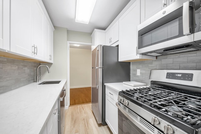 6 Birchwood Ct Unit 4G, Mineola, NY 11501 - kitchen featuring stainless steel appliances, light wood-style flooring, white cabinetry, decorative backsplash, and light stone counters