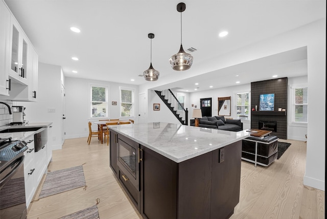 39 Frost Ln, Cornwall, NY 12518 - kitchen with light wood-type flooring, stainless steel range oven, glass insert cabinets, built in microwave, and recessed lighting
