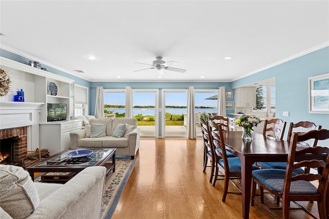 2055 Bay Shore Rd, Greenport, NY 11944 - living room featuring crown molding, ceiling fan, a fireplace, light wood-type flooring, and healthy amount of natural light