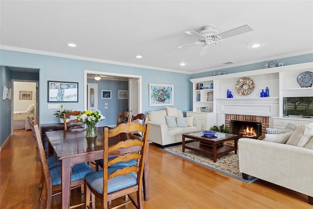 2055 Bay Shore Rd, Greenport, NY 11944 - dining area featuring ceiling fan, light wood-style floors, ornamental molding, a brick fireplace, and recessed lighting