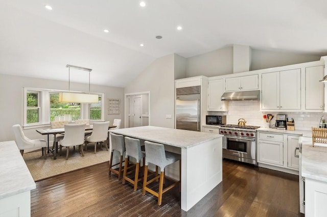 20 Stratton Sq, East Hampton, NY 11937 - kitchen with high end appliances, under cabinet range hood, lofted ceiling, a kitchen island, and decorative backsplash