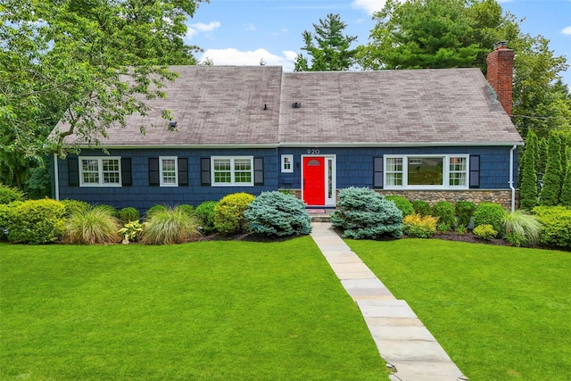 920 Protano Ln, Mamaroneck, NY 10543 - cape cod house with a chimney, a shingled roof, a front lawn, and stone siding