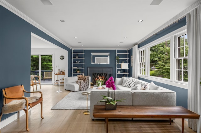 920 Protano Ln, Mamaroneck, NY 10543 - living area with built in features, ornamental molding, a brick fireplace, wood finished floors, and recessed lighting
