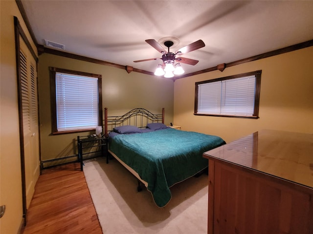25 Herman Ave, North Babylon, NY 11703 - bedroom featuring crown molding, light wood-style flooring, a closet, and ceiling fan