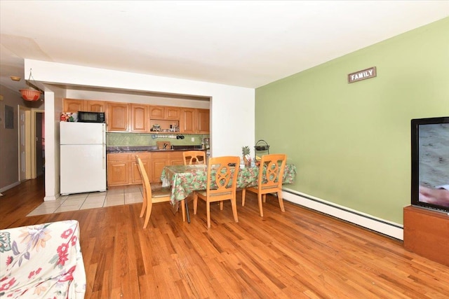 35-44 104th St, Corona, NY 11368 - dining area with a baseboard heating unit and light wood-type flooring