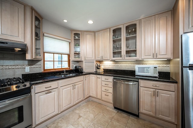 84 Macarthur Ln, Tarrytown, NY 10591 - kitchen featuring appliances with stainless steel finishes, range hood, tasteful backsplash, glass insert cabinets, and dark stone counters