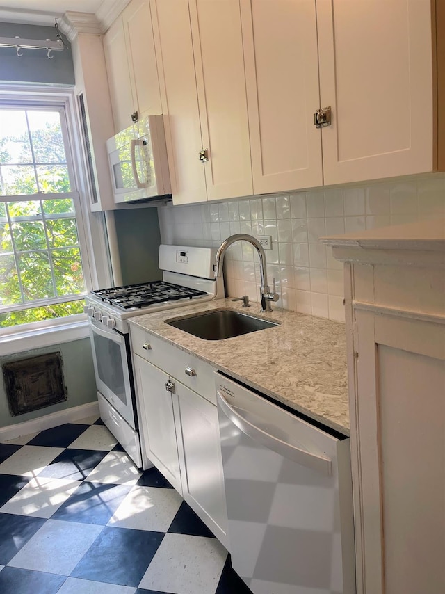 85 N Broadway Unit 2H, White Plains, NY 10603 - kitchen with white appliances, tile patterned floors, white cabinetry, and tasteful backsplash