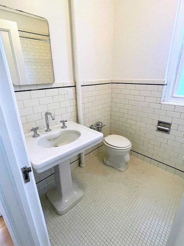 85 N Broadway Unit 2H, White Plains, NY 10603 - bathroom featuring tile walls, wainscoting, and tile patterned flooring