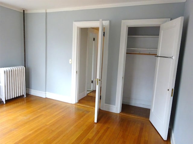 85 N Broadway Unit 2H, White Plains, NY 10603 - unfurnished bedroom with radiator, a closet, and light wood-style flooring