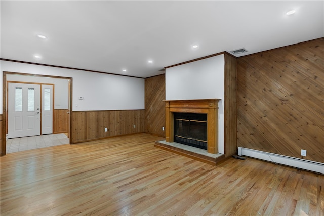 920 Mount Vernon Rd, Wurtsboro, NY 12790 - unfurnished living room with wooden walls, a baseboard radiator, crown molding, light wood-style flooring, and a glass covered fireplace